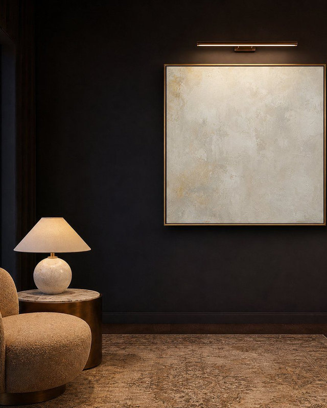 A dusk sitting area lit by a table lamp at seated eye level and a picture light over an ivory plaster artwork, warm low light against the Dubai skyline, Studio Sakaia, Dubai