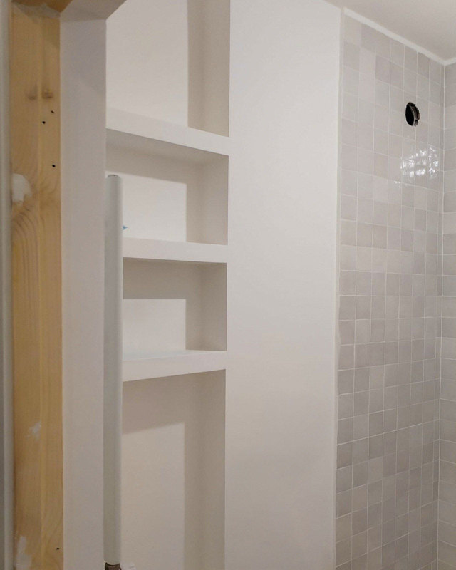 A staggered wall niche in plaster beside a tiled shower wall, before styling, from Studio Sakaia's own Dubai renovation