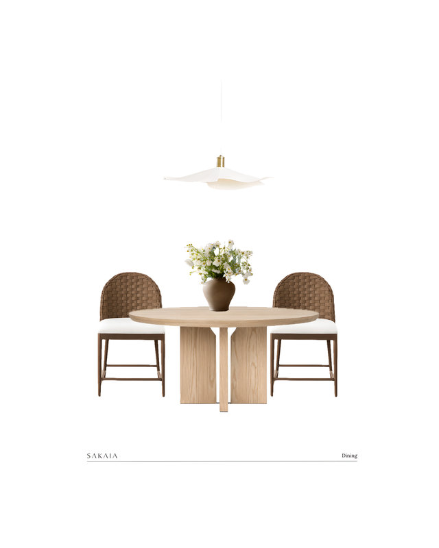 A dining room design board: a round pedestal table in light oak, two woven-back dining chairs, a pleated fabric pendant light in brass and ivory, and a stoneware vase of white flowers.