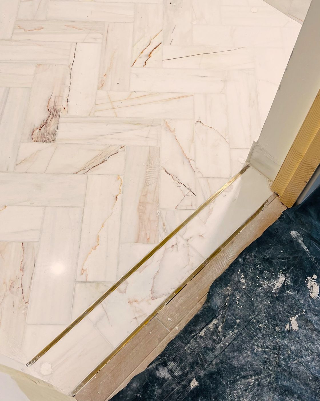 A macro detail of the brass line inlaid in the marble at the doorway threshold, Studio Sakaia, Dubai