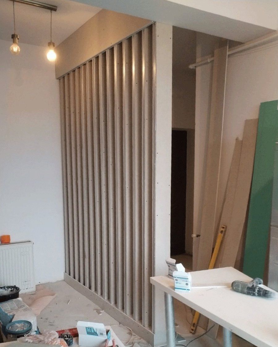 The room divider under construction, raw studs against the site clutter of tools and materials, Studio Sakaia, Dubai