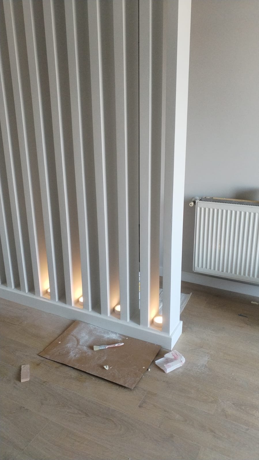 The clad and painted slatted screen with early styling, a candle on the sill, Studio Sakaia, Dubai