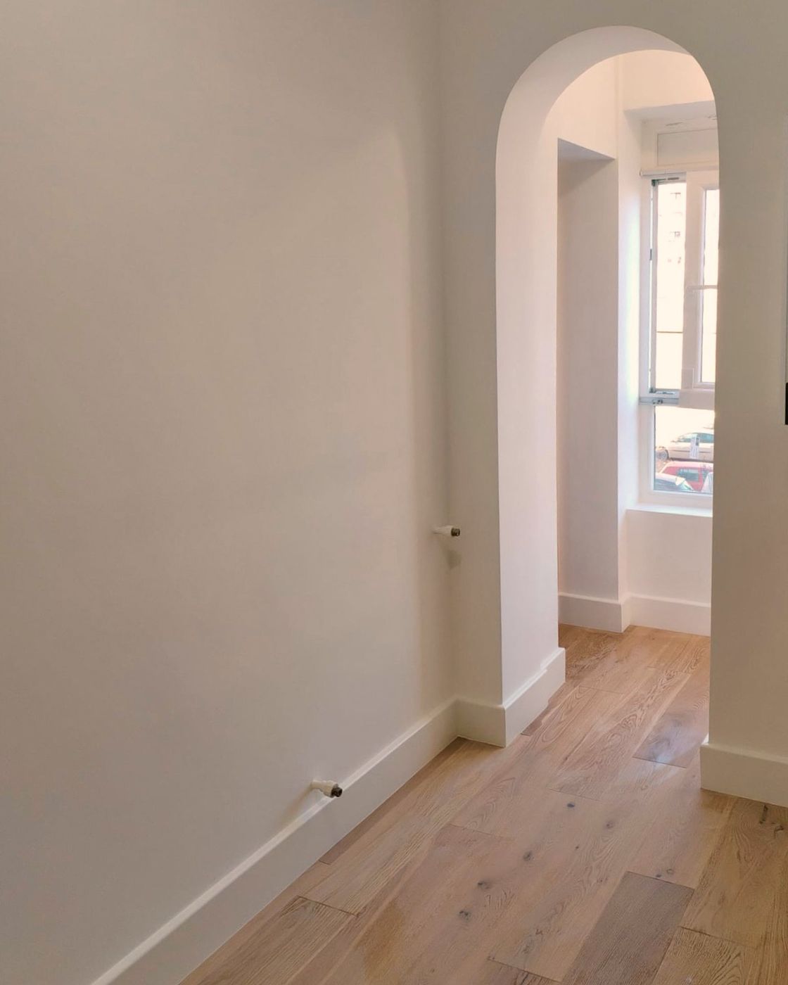 Engineered oak flooring seen through an arched doorway, Studio Sakaia, Dubai
