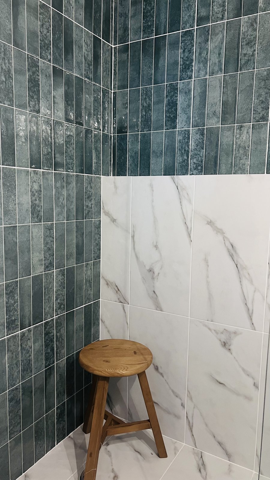 A finished bathroom with fluted teal tile, marble surfaces and a built vanity, warm light, from Studio Sakaia's own Dubai renovation
