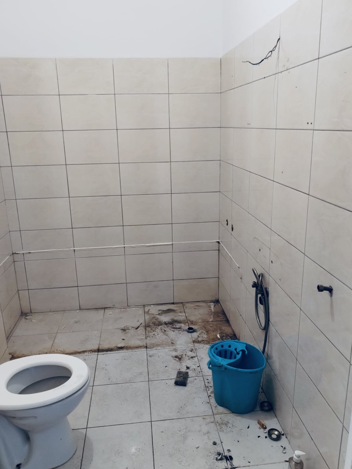 The bathroom before, tired tile and dated fittings, Studio Sakaia, Dubai