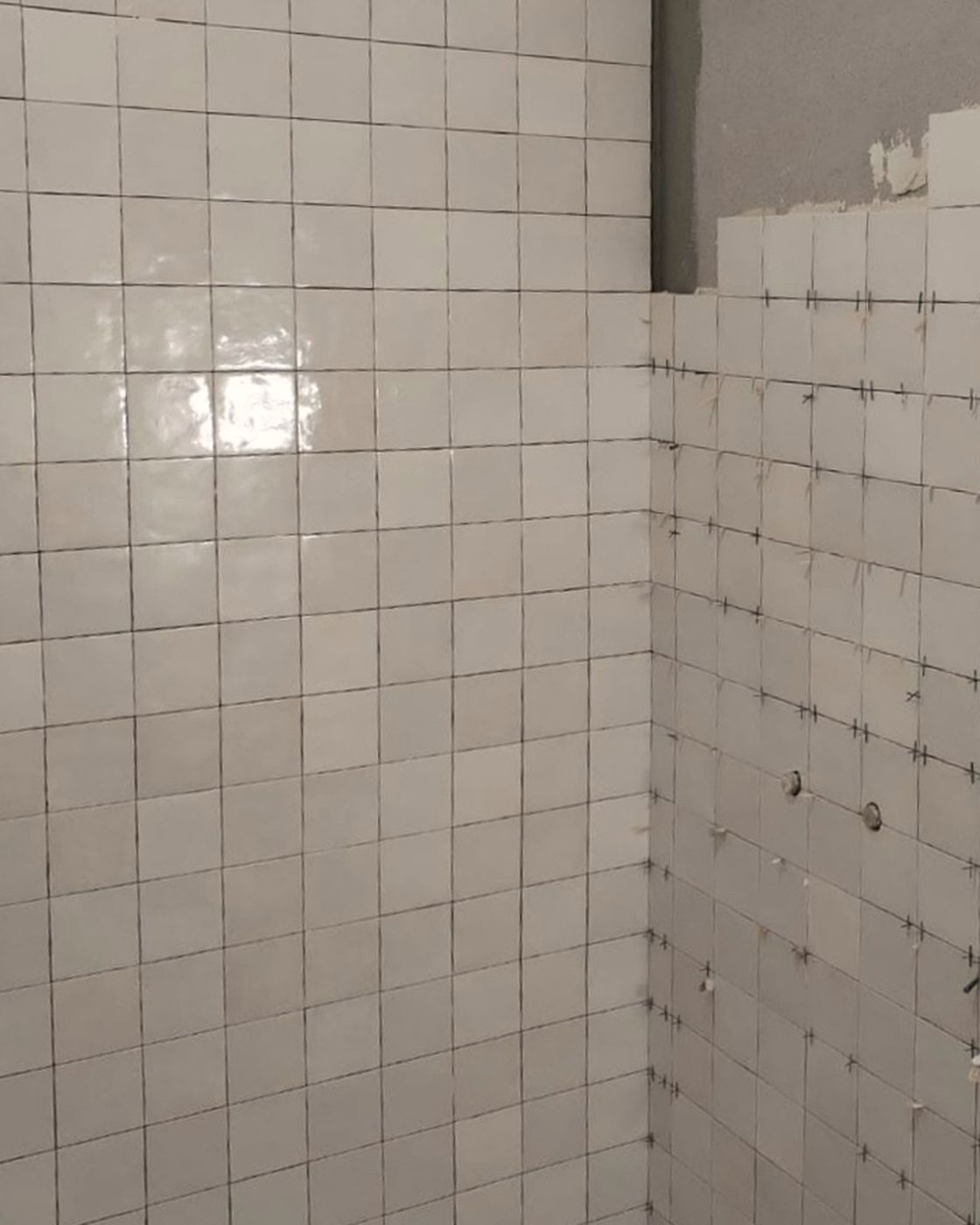Zellige-look tile walls progressing around a corner, tiling still underway on the return wall, Studio Sakaia, Dubai