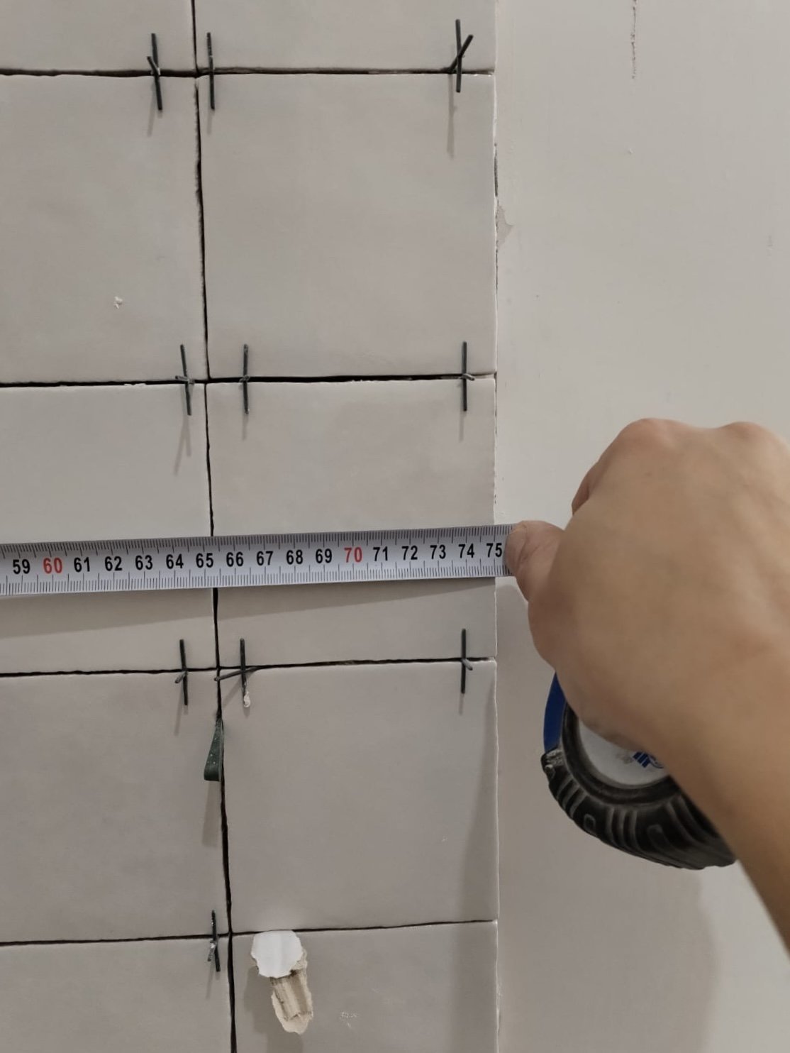 A tile-spacing measurement during setting out, Studio Sakaia, Dubai