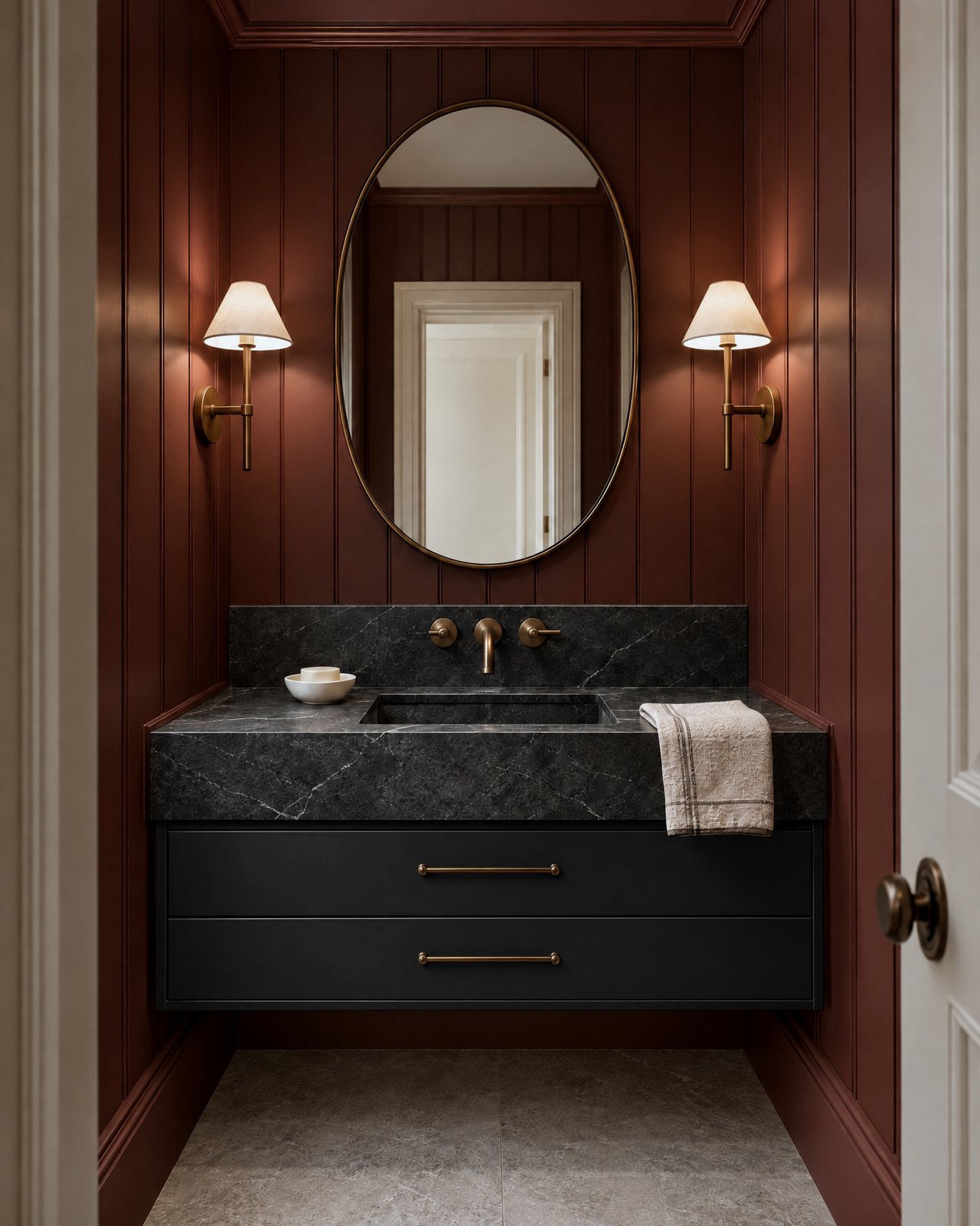 Black wall-hung vanity with a honed soapstone top and backsplash against oxblood panelling, with antique bronze taps, design visualisation by Studio Sakaia.
