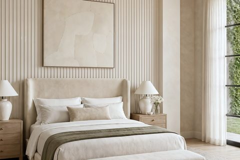 A cream Dubai primary bedroom with a fluted plaster headboard wall, an upholstered bed and a garden view, Studio Sakaia