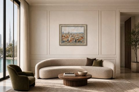 A staged Dubai living room with a curved cream sofa, an olive velvet armchair and a Barcelona Rooftops artwork above, Studio Sakaia, Dubai